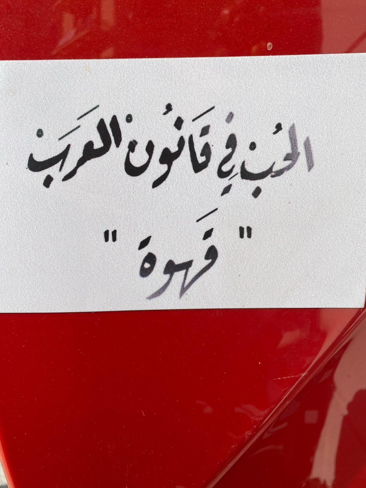عبارة مكتوبة بالخط العربي: الحب في قانون العرب قهوة